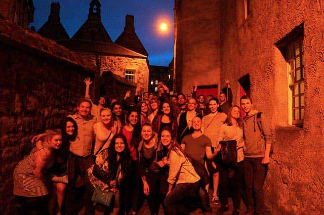 Grupo del pub crawl en un callejón de la Old Town de Edimburgo